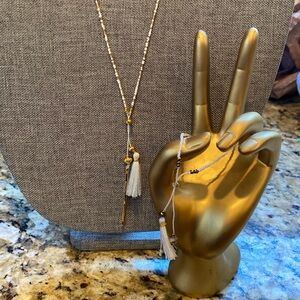 Gorjana long and dainty beaded necklace with white tassel and bracelet.